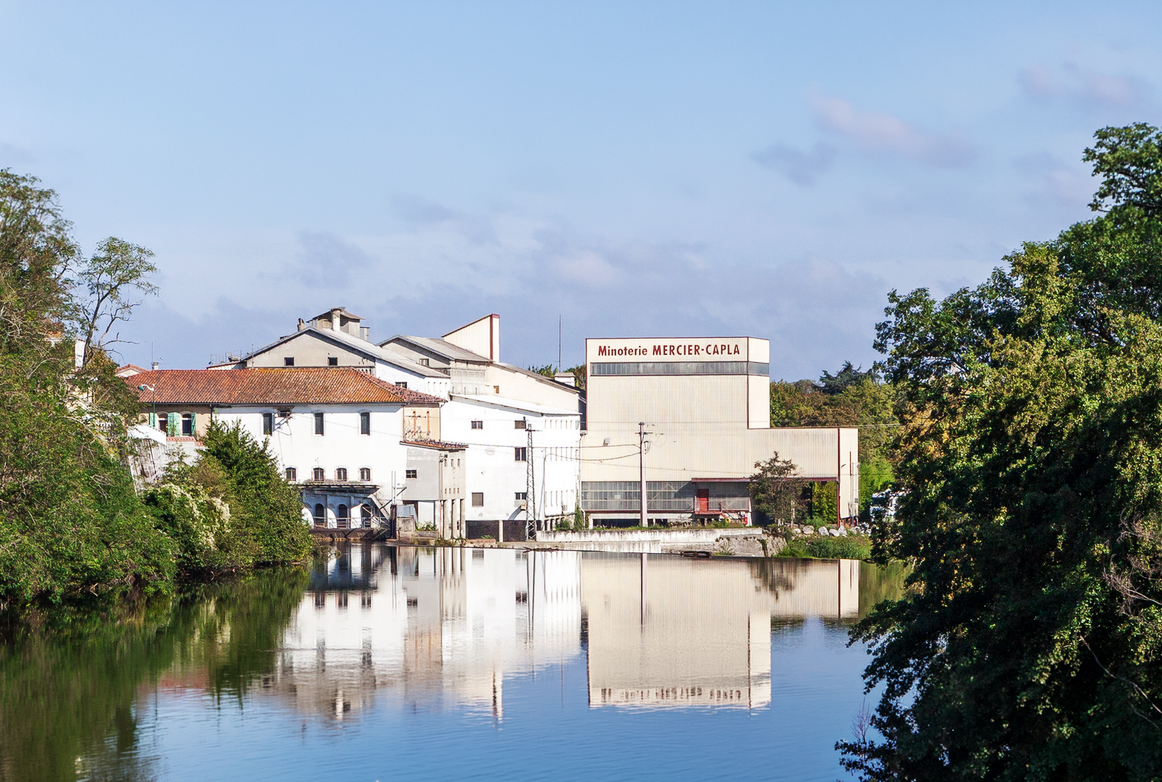 Photographie d'un bâtiment industriel au bord d'une rivière