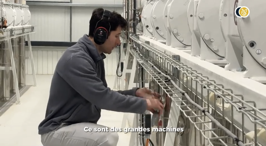 Un homme manipulant des grandes machines industrielles avec un casque anti-bruit sur la tête